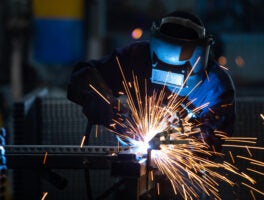 Workers,Wearing,Industrial,Uniforms,And,Welded,Iron,Mask,At,Steel